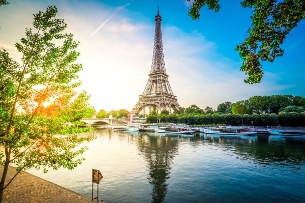 Paris Eiffel Tower and river Seine with sunrise sun in Paris, France. Eiffel Tower is one of the most iconic landmarks of Paris, toned